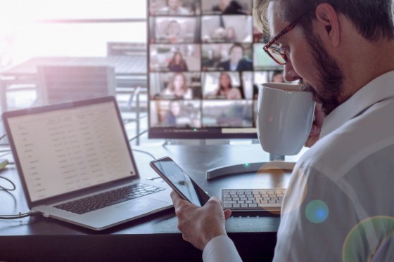 man-sipping-coffee-doing-business-video-chat-EX3AUF7